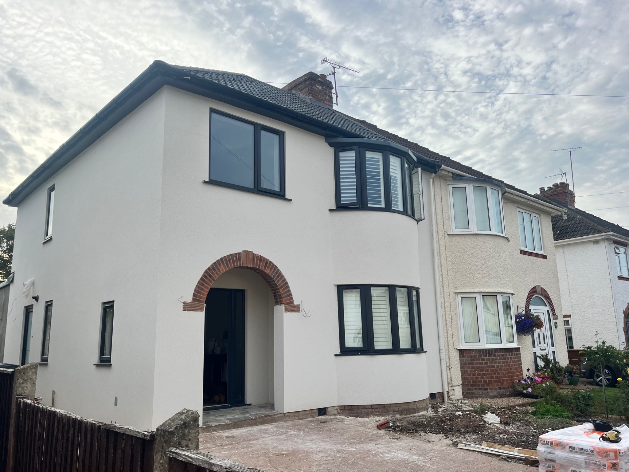Front elevation of a rendered home with dark window frames